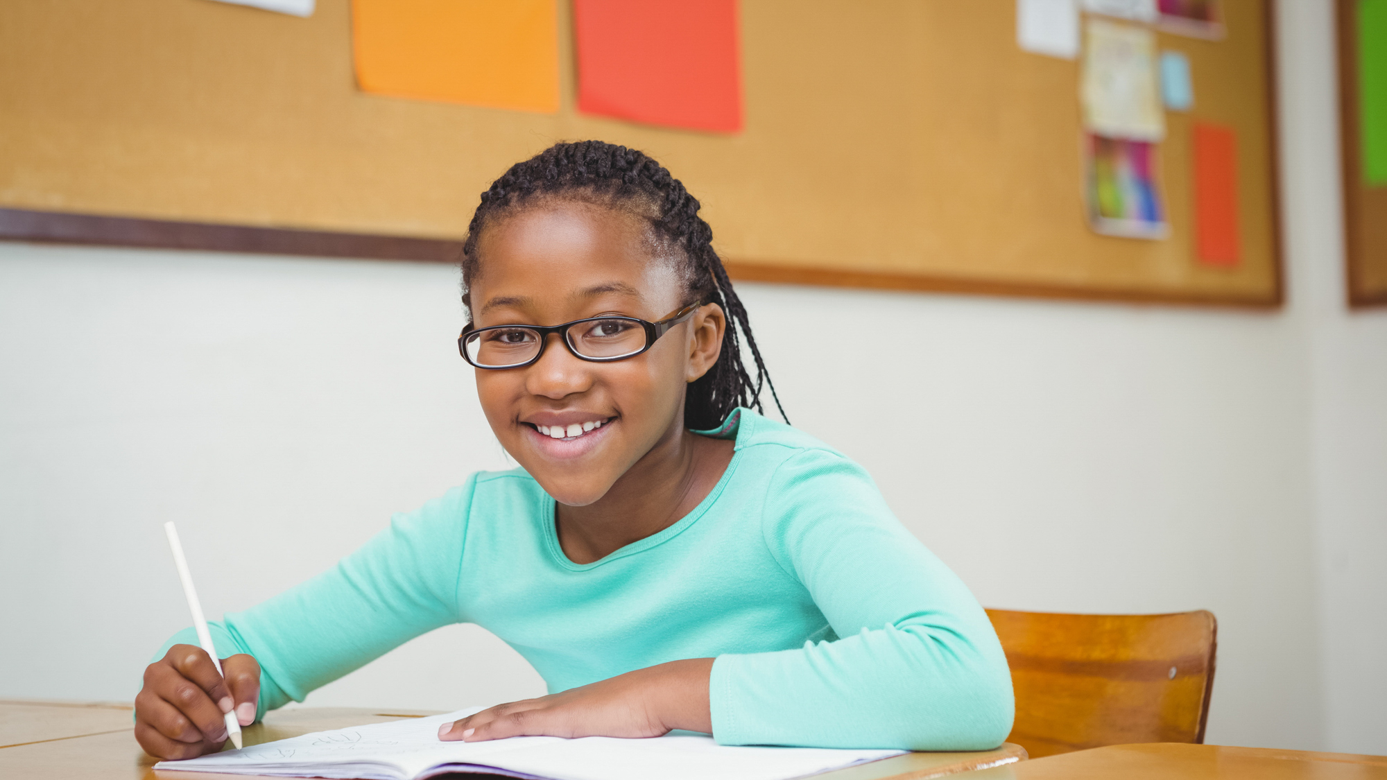 African american girl in glasses smiling at a desk