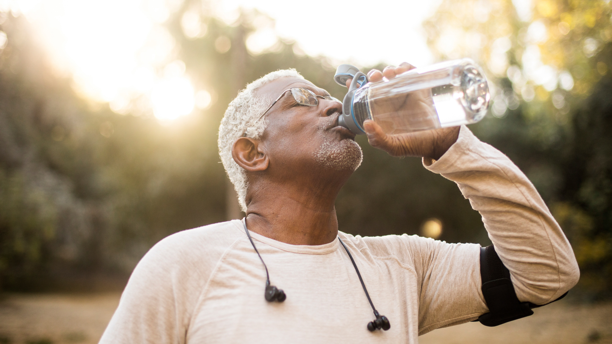 A senior African American Man enjoying refreshing water after a workout