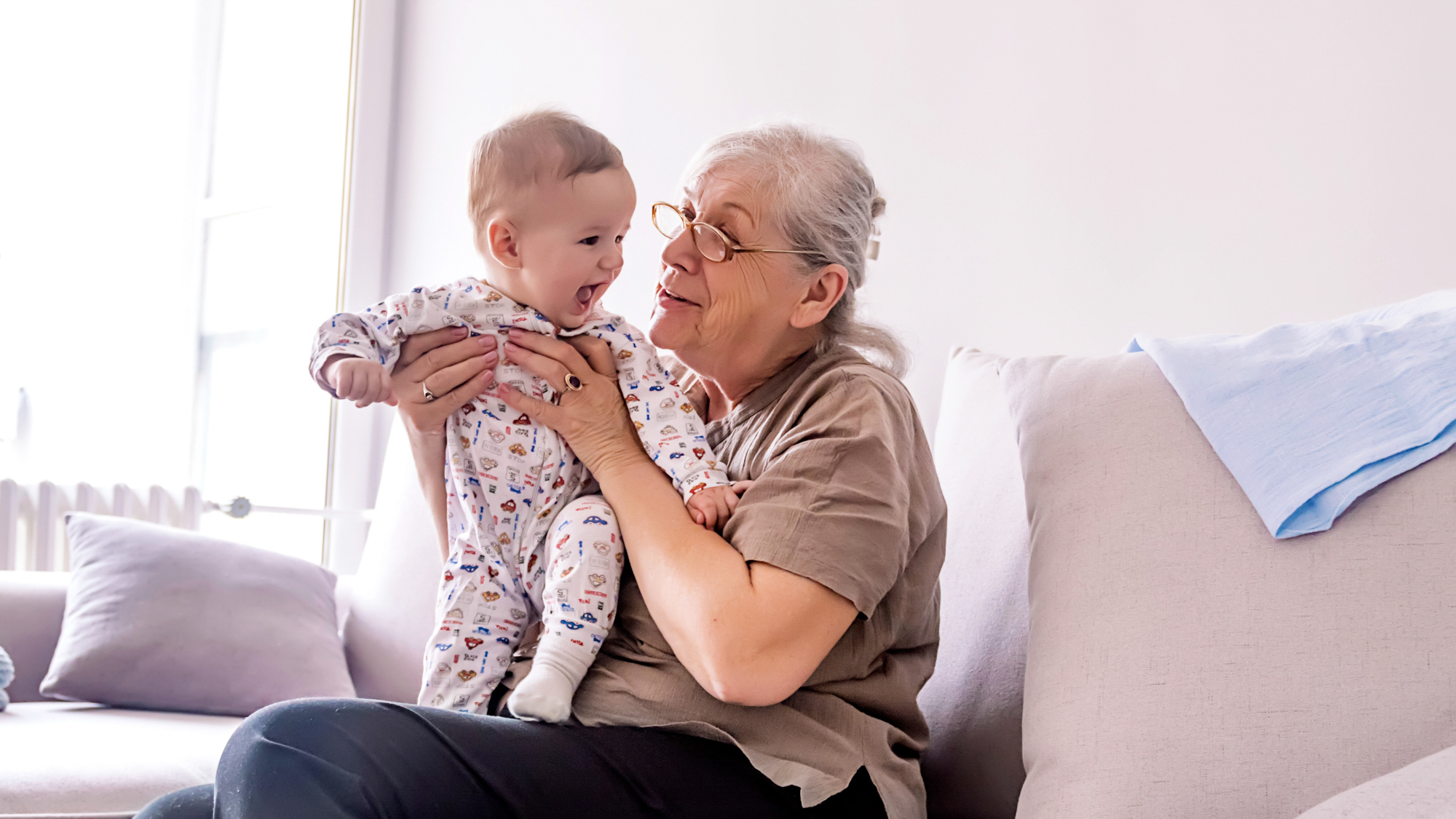 grandmother holding a smiling infant