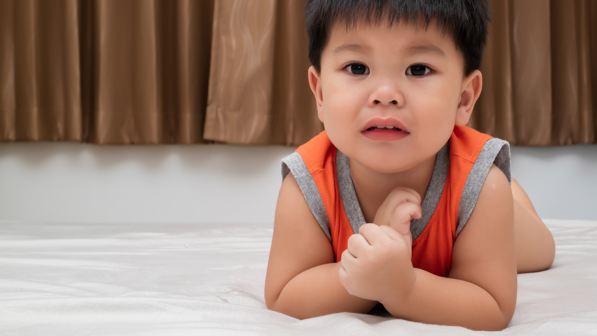Male Asian Toddler on elbows