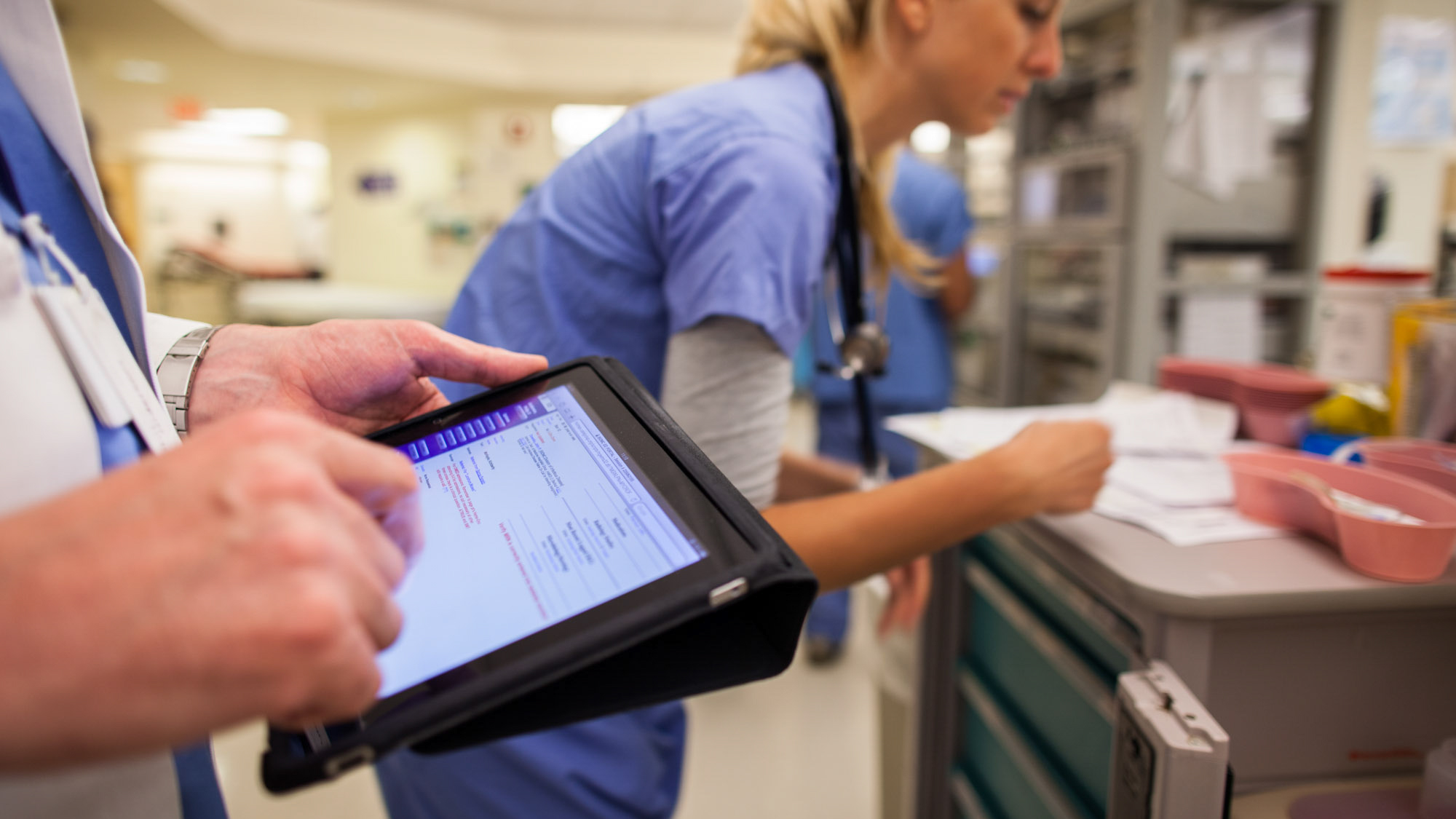 clinicians entering data into a tablet