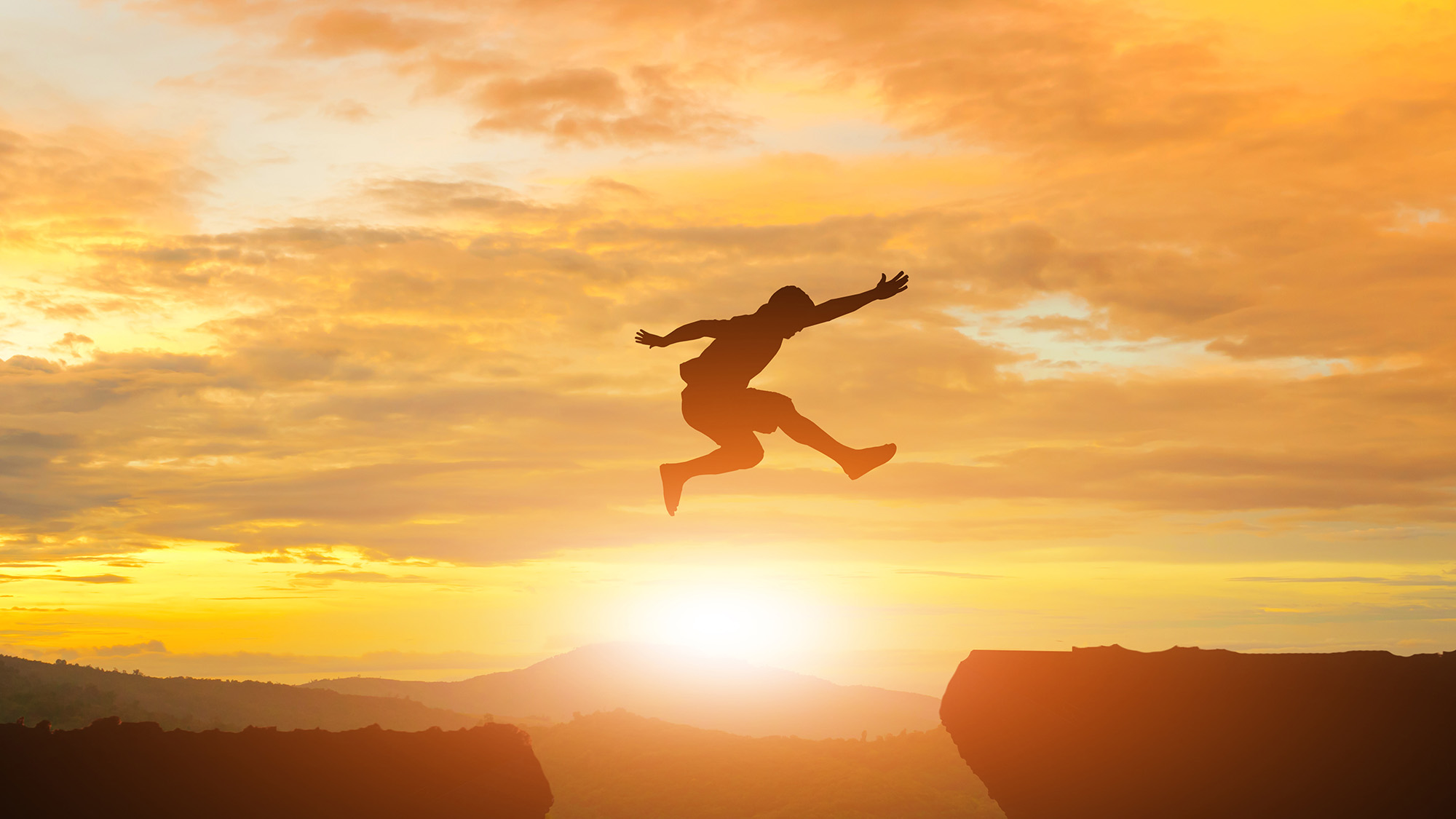 person leaping over a chasm