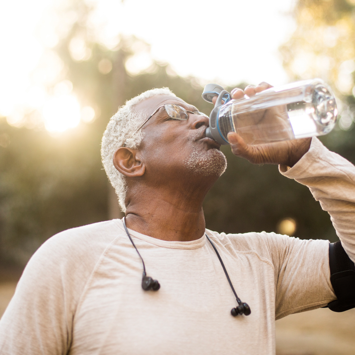 A senior African American Man enjoying refreshing water after a workout