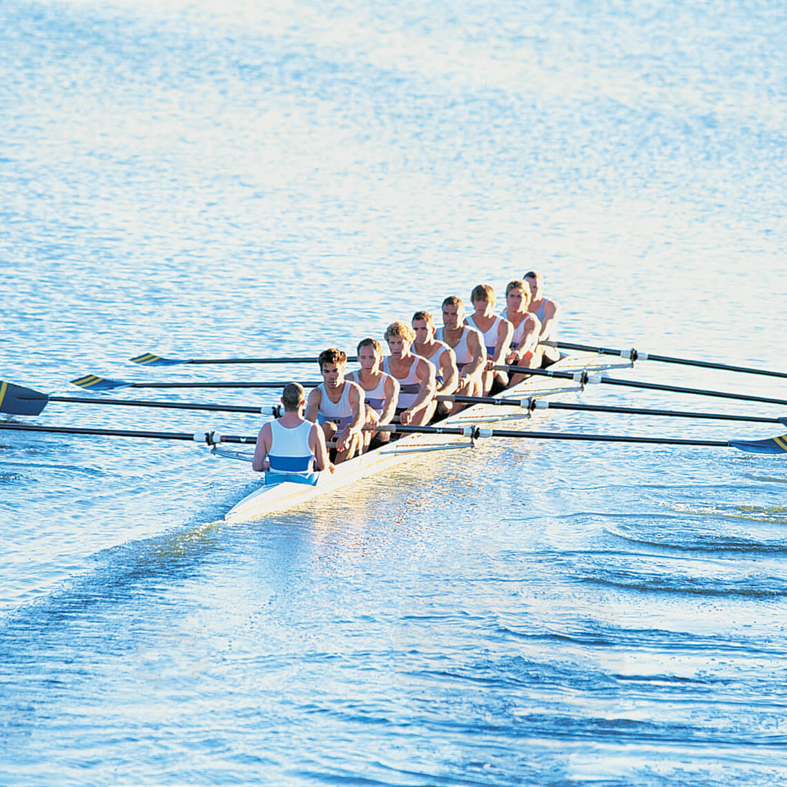 Crew rowing on river