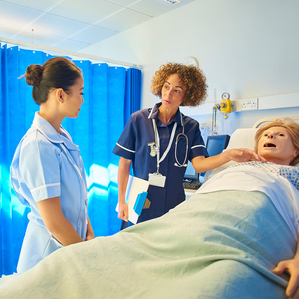 clinicians next to a medical simulation manikin