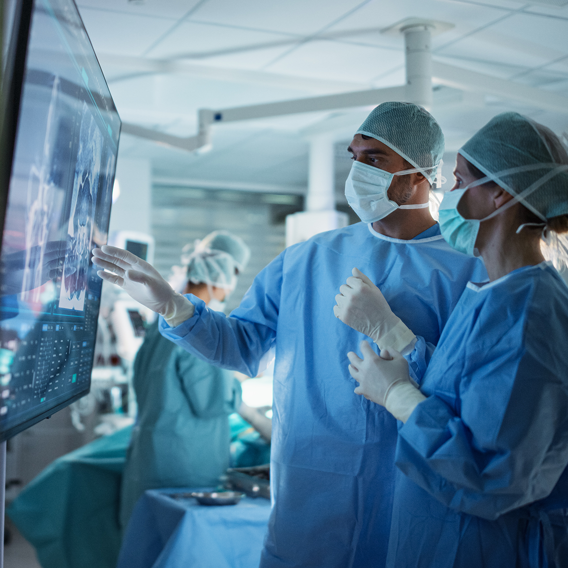 two clinicians discussing a chart on a screen in square format