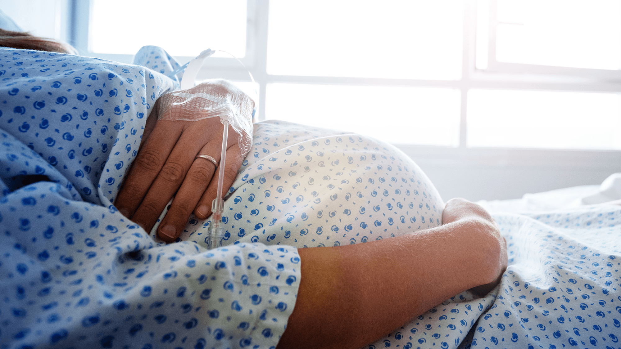 pregnant belly in hospital gown with hand across rectangular image