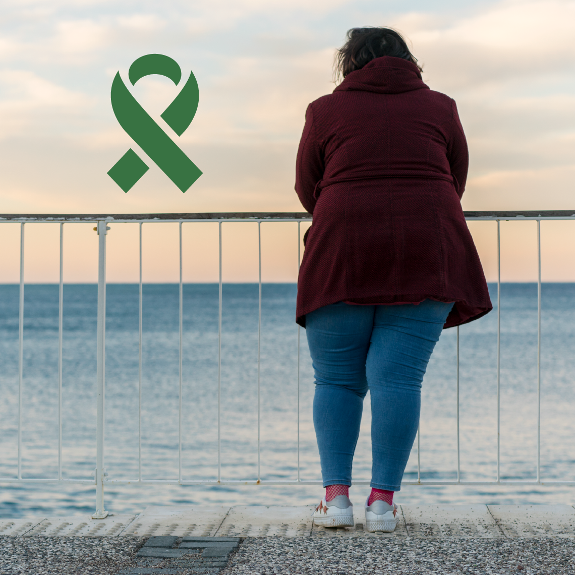 Mental Health Awareness Month. A woman looks out at the ocean with her back to the camera.