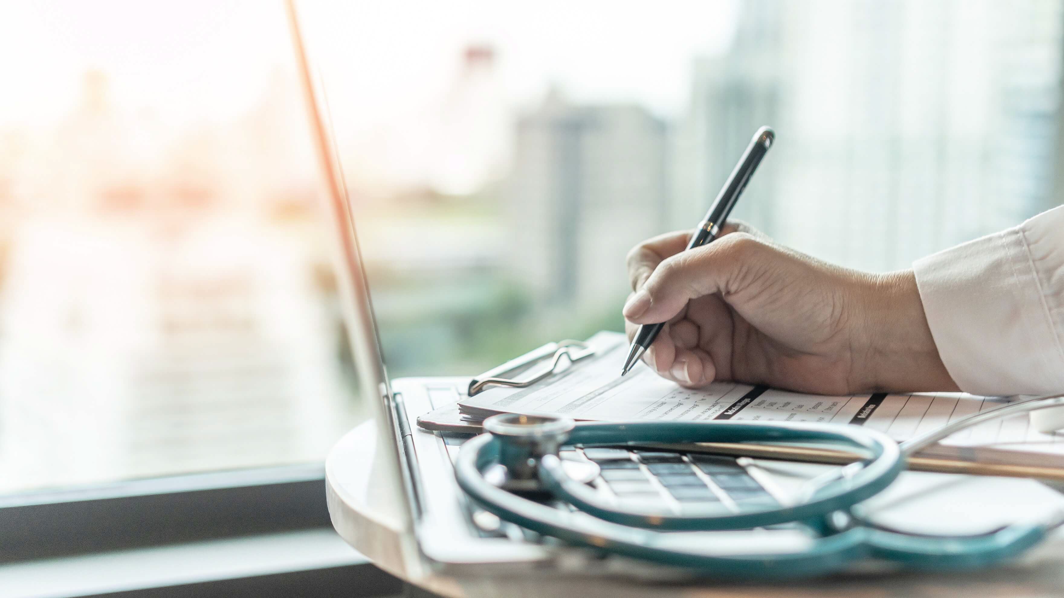 doctor hand writing with a pen on a clipboard