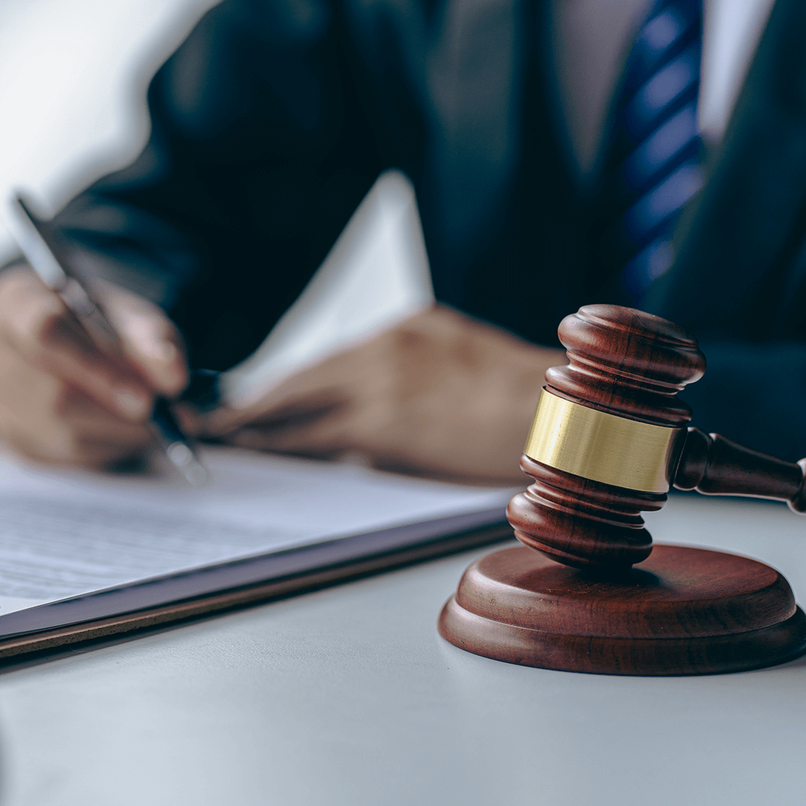 gavel and hand with pen